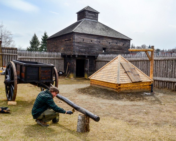 Hannes Moll paints an ox cart with boat soup, a mixture of pine tar, boiled linseed oil and turpentine, in 2018 at Old Fort Western in Augusta. 