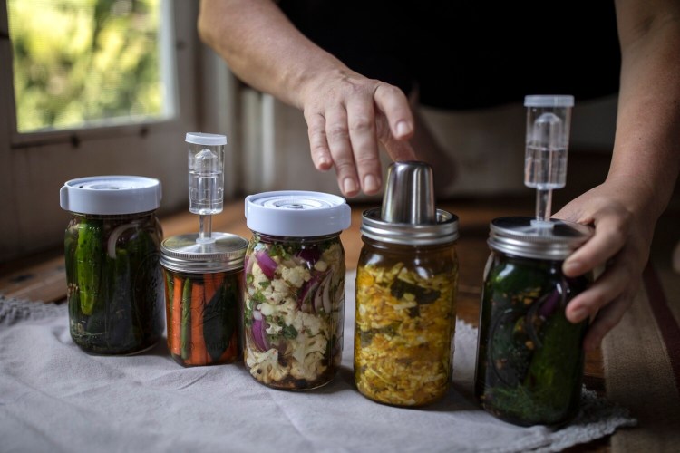 Fermentation bounty: From left, dill pickles; fermented carrots with green beans and bay leaves; fermented cauliflower with red onions; golden sauerkraut; and more dill pickles.