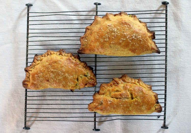 Curried local-vegetable hand pies cool on a cooling rack. 