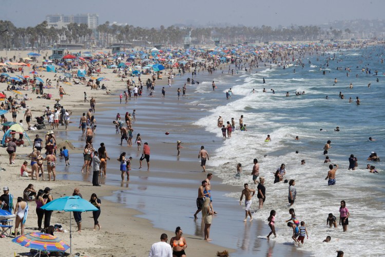 Visitors crowd the beach in Santa Monica, Calif., amid the coronavirus pandemic on July 12. The state faces a heat wave that could bring dangerously high temperatures throughout the state, along with the threat of wildfires and spreading coronavirus infections as people flock to beaches and recreation areas. 