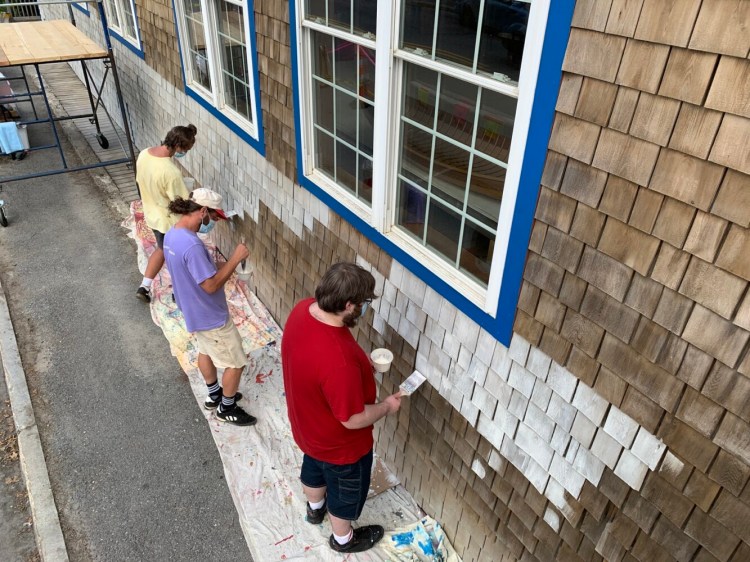 Project Interns work with AiA Mentor Artist Zack Winklhofer, center, to apply a base coat to the Main Street elevation of the Apprenticeshop in Rockland.