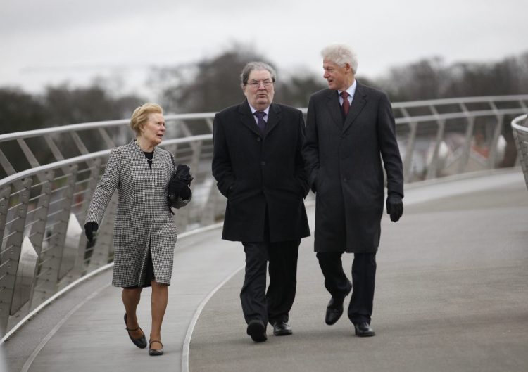 Former President Bill Clinton, right, with former Social Democratic Labour Party leader John Hume and Hume's wife Pat walk across the Peace Bridge, in Londonderry Northern Ireland in 2014. 