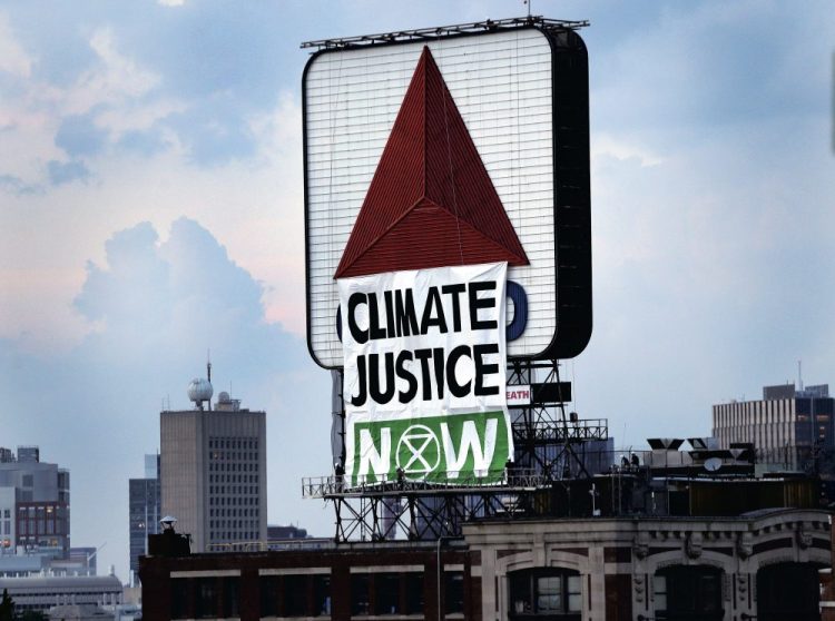 Members of an environmental group hung this banner on the iconic Citgo sign near Boston's Fenway Park on Monday. (Jim Davis/The Boston Globe via AP)