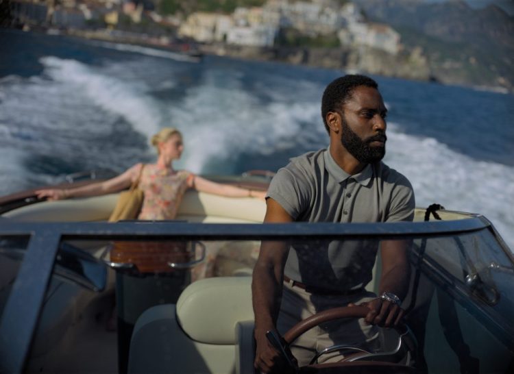 This image released by Warner Bros. Entertainment shows Elizabeth Debicki and John David Washington in a scene from "Tenet." Some U.S. moviegoers will be able to see Christopher Nolan’s “Tenet” a few days early. Warner Bros. on Tuesday said that it would be offering early access screenings starting Aug. 31 as a gesture of support to the domestic theaters that are reopening after five months of being closed because of COVID-19. 