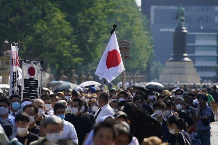 Worshippers queue to pay respects to the war dead at Yasukuni Shrine on Saturday in Tokyo. Japan marked the 75th anniversary of the end of World War II. 

