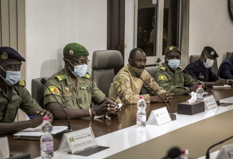 Col. Assimi Goita, center, who has declared himself the leader of the National Committee for the Salvation of the People, is accompanied by group spokesman Ismael Wague, left, and group member Malick Diaw, center-left, as they meet with a high-level delegation from the West African regional bloc known as ECOWAS, at the Ministry of Defense in Bamako, Mali, Saturday.
