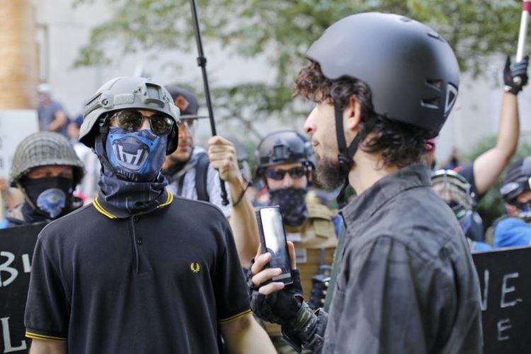 Opposing rallies battle with mace, paint balls and rocks near Justice Center in downtown Portland, Oregon, Saturday. Dueling demonstrations in Portland by right-wing and left-wing protesters have turned violent near a county building that's been the site of numerous recent protests.