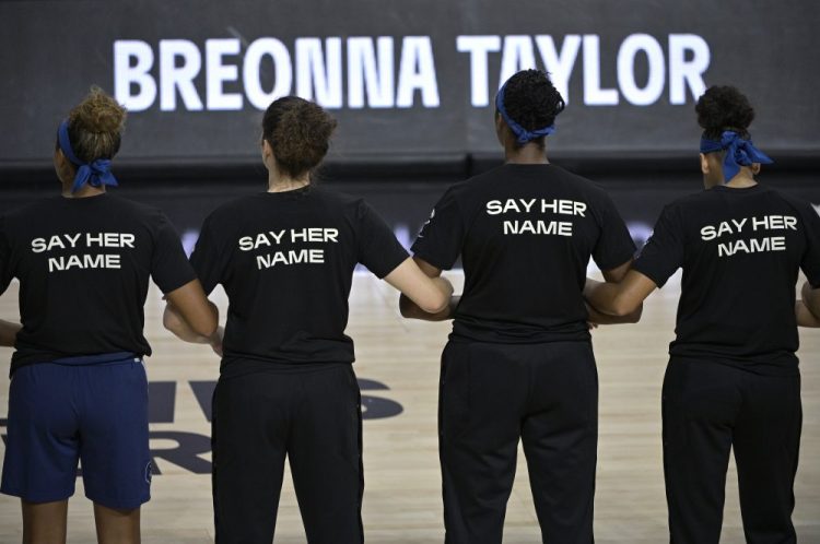 Minnesota Lynx players lock arms during a moment of silence in honor of Breonna Taylor before a WNBA basketball game against the Connecticut Sun on  July 26 in Bradenton, Fla. 