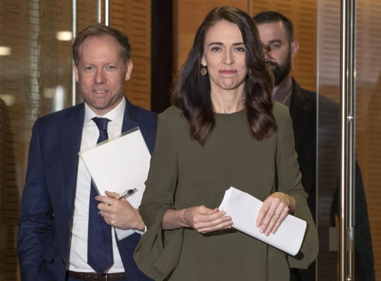 New Zealand Prime Minister Jacinda Ardern, center, arrives to announce a new date for national elections, at a news conference in Wellington, New Zealand, on Monday. The election had been scheduled for Sept. 19 but will now be held on Oct. 17, after a COVID-19 outbreak in Auckland. 