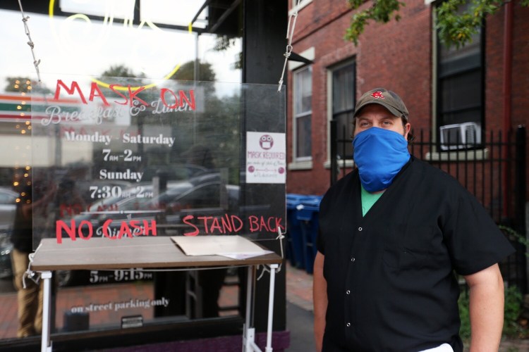 PORTLAND, ME - SEPTEMBER 3: Moses Sabina, co-owner and chef at Hot Suppa, sometimes positions himself outside the restaurant to welcome guests from behind the clear-plastic barrier and to enforce mask-wearing and social distancing. (Staff photo by Ben McCanna/Staff Photographer)