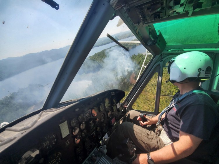 Maine Forest Ranger Jeff Miller  surveys a fire near Moosehead Lake this summer, one of more than 900 so far this year in the state.