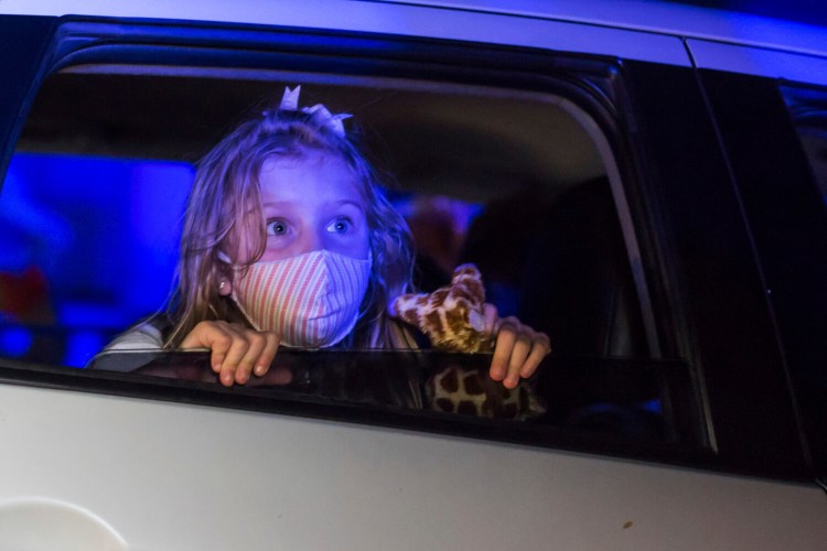 A girl watches a performance from inside a car at the Hopi Hari horror theme amusement park in the Vinhedo suburb of Sao Paulo, Brazil, on Friday. Due to the restrictions caused by COVID-19, the park created a drive-thru tour.
