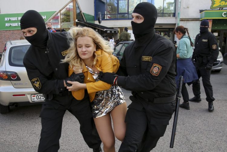 Police officers detain a woman on Saturday during an opposition rally to protest the official presidential election results in Minsk, Belarus. Daily protests calling for the authoritarian president's resignation are now in their second month and opposition determination appears strong despite the detention of protest leaders. 