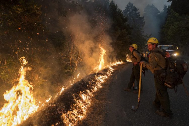Firefighters monitor a controlled burn along Nacimiento-Fergusson Road to help contain the Dolan Fire near Big Sur, Calif., on Friday.