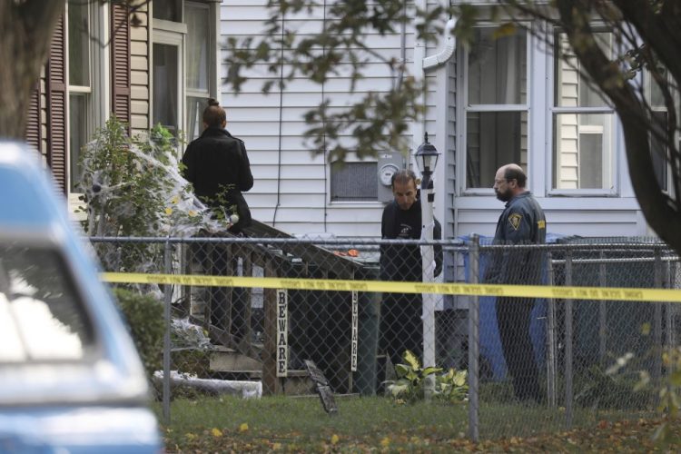 Rochester police look over the area of a home after a fatal shooting at a backyard party, on Saturday in Rochester, N.Y. Police are still trying to piece together who opened fire and why. 