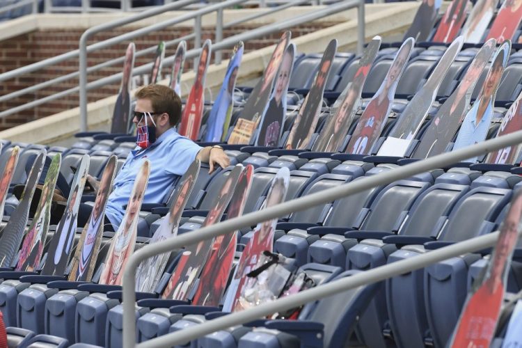 A fan sits among cardboard cutouts of other fans before the first half of an NCAA college football game between Mississippi and Florida in Oxford, Miss., on Saturday. Thomas Graning/Associated Press