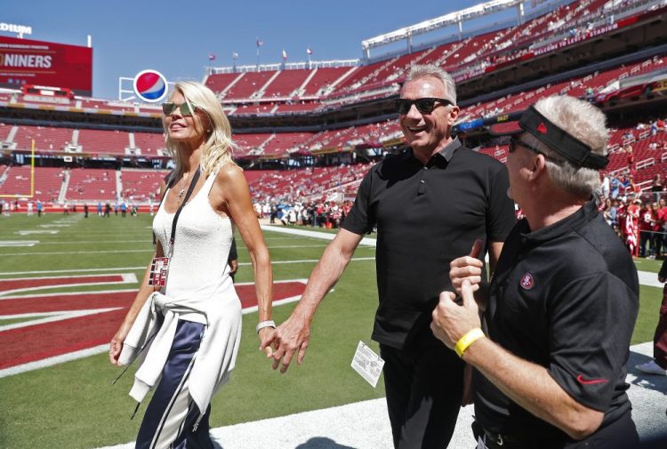 Joe Montana and his wife, left, Jennifer walk onto the field at Levi's Stadium Sept. 16, 2018,  before an NFL football game between the San Francisco 49ers and the Detroit Lions in Santa Clara, Calif.