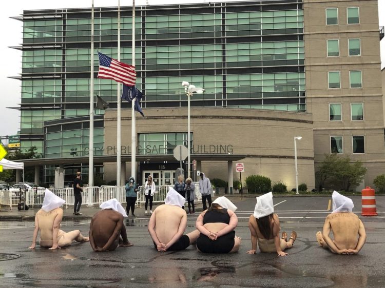 Naked protesters, wearing "spit hoods" in reference to the killing of Daniel Prude, demonstrate outside Rochester's Public Safety Building in Rochester, N.Y., on Monday. 
