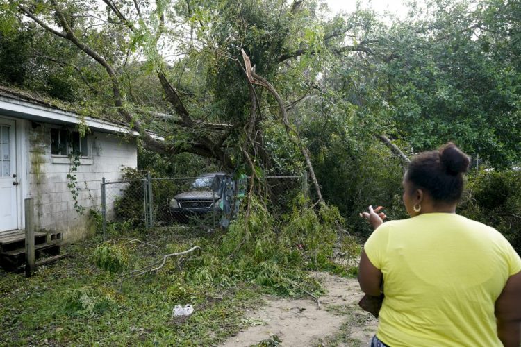 Seleka Souls looks over a neighbor's home that was damaged by Hurricane Sally, on Friday in Pensacola, Fla. 
