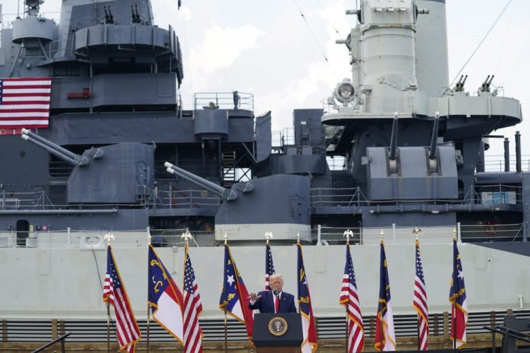 With the USS Battleship North Carolina in the background, President Trump speaks during an event to designate Wilmington as the first American World War II Heritage City, on Wednesday in Wilmington, N.C. 
