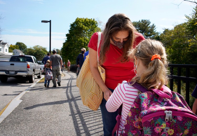 Stephanie Bethel greets her daughter Juliet at Ocean Avenue Elementary School in Portland on Thursday. Bethel, who moved to Portland this year a few weeks before the schools closed due to COVID-19, supports the decision to hold off on full-week in-person learning and is thankful that her daughter, who is in second grade, is able to attend school at least a few days a week. 