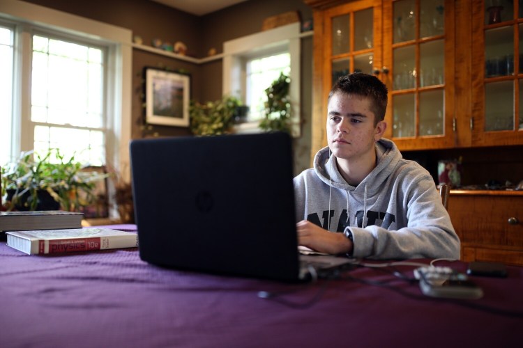 PORTLAND, ME - OCTOBER 5: George Theall, is a junior at Portland High School, attends a remote learning class from his dining room. Theall is among students and parents who are pushing for more in-person learning after the district decided continue to incorporate remote learning for the time being. (Staff photo by Ben McCanna/Staff Photographer)