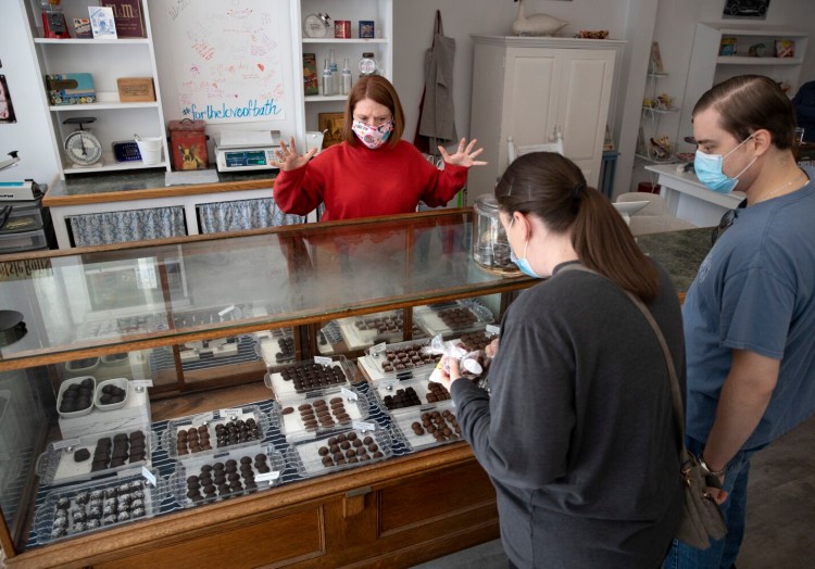Bath Sweet Shoppe owner Jennifer DeChant helps customers Karen and Richard Andrews of Southbury, Connecticut, at the store on Oct. 22. DeChant is one of hundreds of Mainers that have acquired or launched their own business ventures since the coronavirus pandemic began.