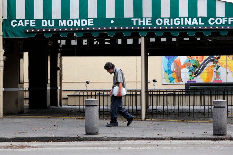 FILE - In this Friday, March 27, 2020, file photo, a man walks past the closed Cafe Du Monde restaurant in the French Quarter of New Orleans. Prospects for more federal stimulus this year appear all but dead, clouding the future for the unemployed, for small businesses and for the economy as a whole.  (AP Photo/Gerald Herbert, File)