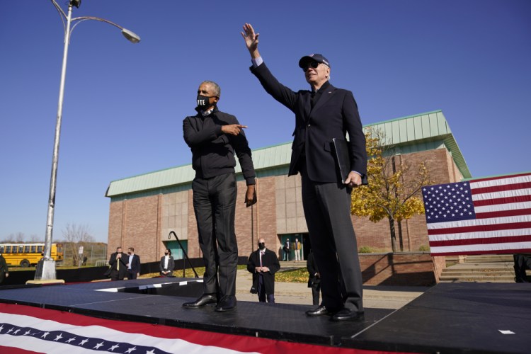 Democratic presidential candidate former Vice President Joe Biden and former President Barack Obama greet each other at a rally at Northwestern High School in Flint, Mich., on Saturday.

