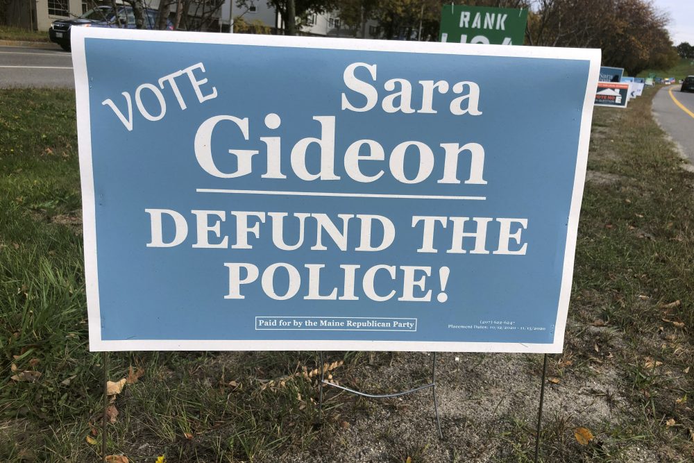 The Maine Republican Party has put up signs claiming Democrat Sara Gideon wants to defund the police after "Trump/Collins" signs, paid for by Democrats, began appearing a few weeks ago. (AP Photo/David Sharp)