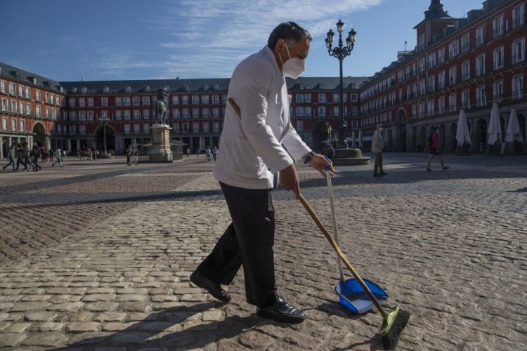 A waiter sweeps the terrace of a bar Oct. 9 in downtown Madrid, Spain.