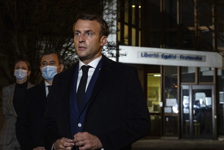 French President Emmanuel Macron, with French Interior Minister Gerald Darmanin, speaks in front of a high school Friday in Conflans Sainte-Honorine, northwest of Paris, after a history teacher was beheaded. He urged the nation to stand united against extremism. 