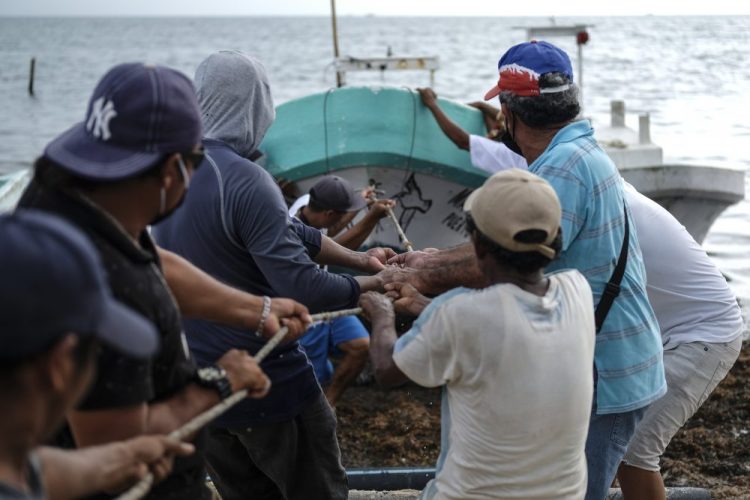 Fishermen pull in a boat before the arrival of Hurricane Delta in Puerto Juarez, Cancun, Mexico, on Tuesday. Delta’s center Tuesday evening was about 180 miles east-southeast of Cozumel, Mexico, and it was moving west-northwest at 17 mph.
