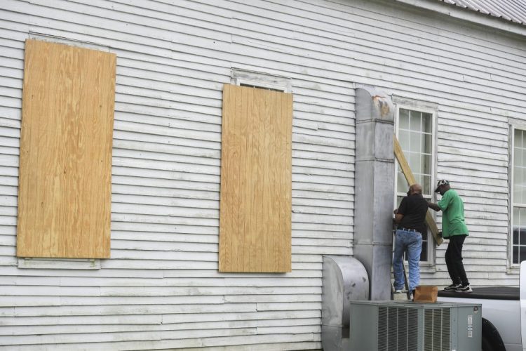The Rev. Ivory Williams Sr. and Chris Welch board up the windows of St. John Baptist Church while preparing for Hurricane Delta on Thursday in Charenton, La. 