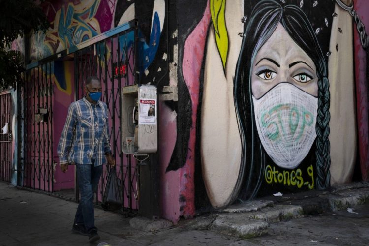 A man walks past a mural Thursday in Los Angeles. 

