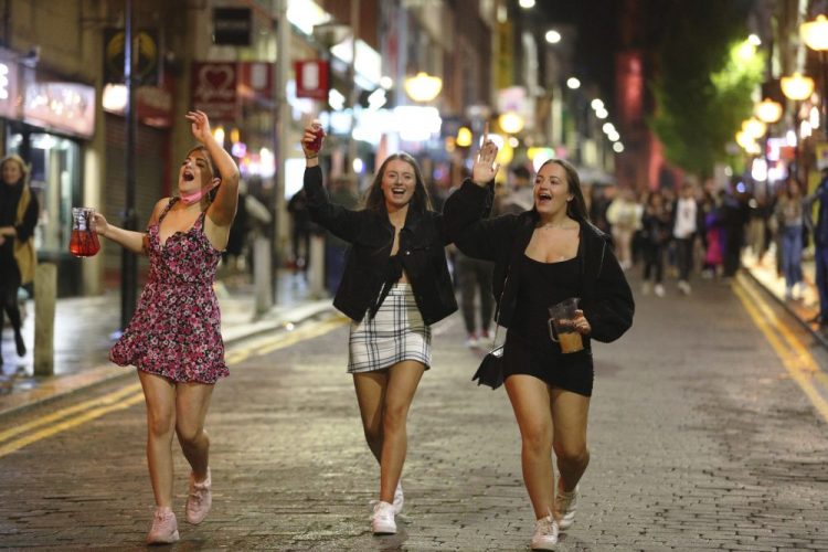 People socialize in Liverpool city centre, ahead of the 10 p.m. curfew that pubs and restaurants are subject to in order to combat the rise in coronavirus cases in England, Saturday.