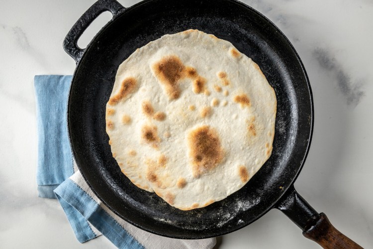 You might hear sizzles or pops as the tortilla blisters across the surface; after about 1 minute, use a spatula to lift and flip it over. There should be a scattering of browned freckles on what is now the top of the tortilla. MUST CREDIT: Photo by Laura Chase de Formigny for The Washington Post.