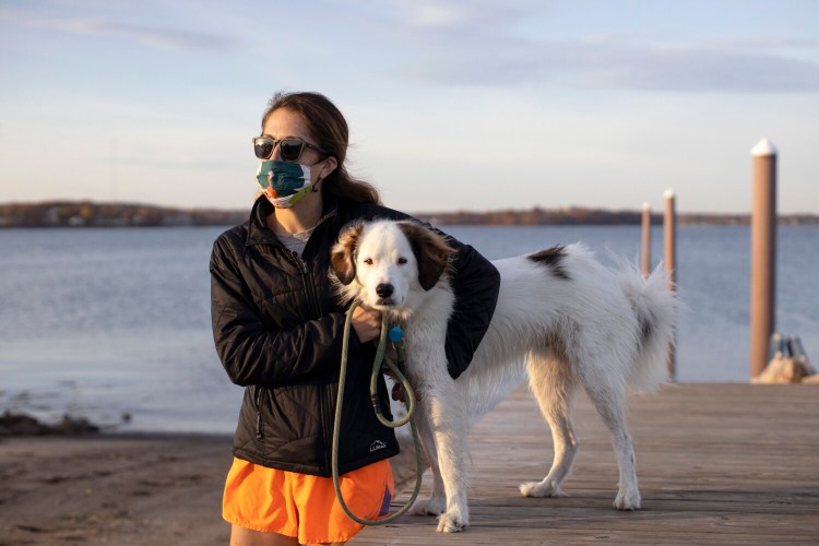 Kathleen Kramer, with  her dog, Blue, at Portland's East End Beach on Friday, said she didn't bring her mask when walking the dog in the past, but will now that masks are mandatory in all public places.