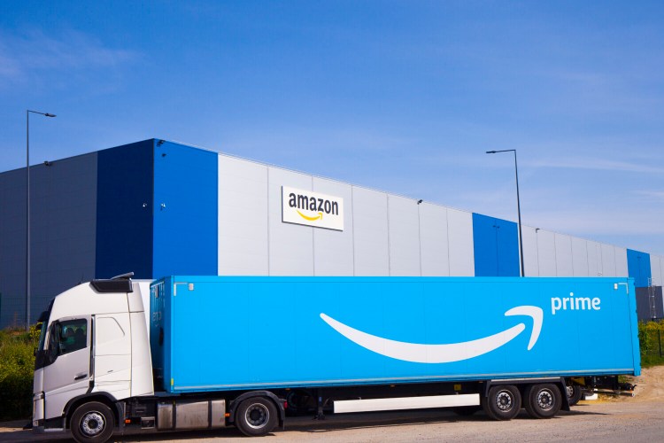 FILE - In this Thursday, April 16, 2020, file photo, a delivery truck at the entrance of Amazon, in Douai, northern France. European Union regulators on Tuesday, Nov. 10, 2020 have filed antitrust charges against Amazon, accusing the e-commerce giant of using data to gain an unfair advantage over merchants using its platform. (AP Photo/Michel Spingler, File)