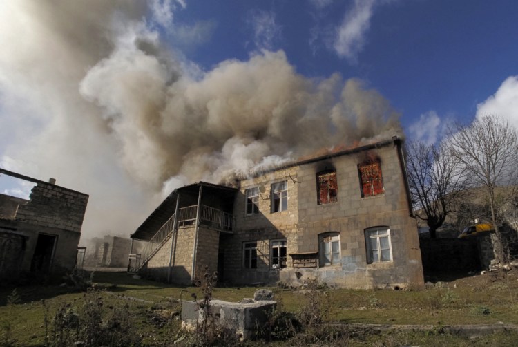 Smoke rises from a burning house in an area once occupied by Armenian forces but soon to be turned over to Azerbaijan, in Karvachar, the separatist region of Nagorno-Karabakh, on Friday. 