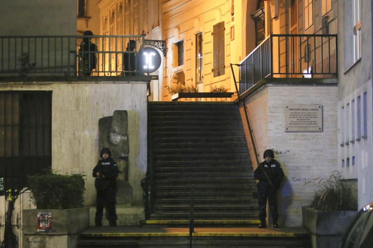 Police officers stay in position near a synagogue after an attack in Vienna killed two people.