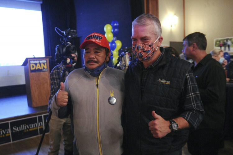 Sen. Dan Sullivan, R-Alaska, right, poses for a photograph with supporter Rolando Torralba at a campaign party this month in Anchorage, Alaska. 