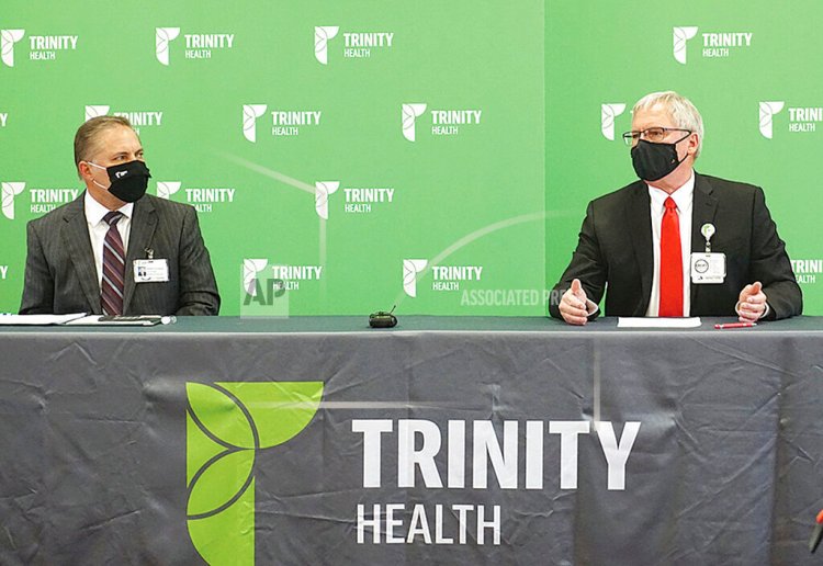 Dr. Jeffrey Sather, chief of staff, right, speaks at a news conference at Trinity Health Friday, Oct. 9, 2020, with Randy Schwan, Trinity vice president, left, in Minot, N.D.   Local hospital workers are becoming overwhelmed as COVID-19 cases in the Minot region, including those in long-term care facilities, have risen significantly in recent weeks.  (Jill Schramm/Minot Daily News via AP)