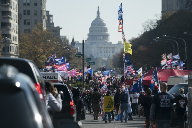 A motorcade carrying President Trump drives by a group of supporters holding a rally near the White House on Saturday.

