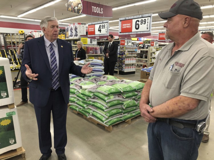 Missouri Gov. Mike Parson, left, talks with store manager Ron Schuman, right, during a tour of the Orscheln Farm & Home store on May 7 in Jefferson City, Mo. Parson was visiting the store to promote the end of a stay-at-home order he had issued because of the  pandemic. Midwest governors credit their lack of restrictions for low unemployment rates, but economists and others say other factors might be more important in the states low jobless rates. 