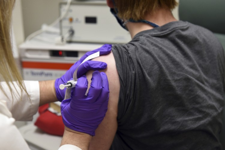 The first patient enrolled in Pfizer's COVID-19 coronavirus vaccine clinical trial receives a shot at the University of Maryland School of Medicine in Baltimore earlier this year. Pfizer has projected having 50 million doses - enough for 25 million people - by the end of the year. 