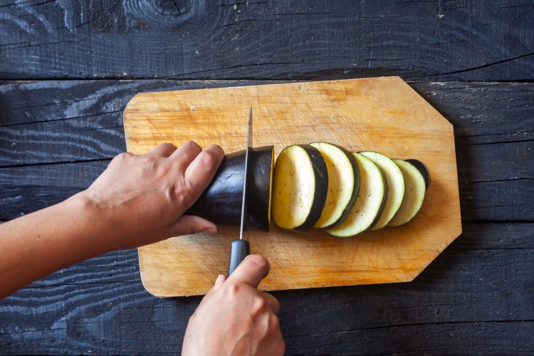 To make Personal Pantry Eggplant Parm, begin by cutting three eggplants into rounds. 