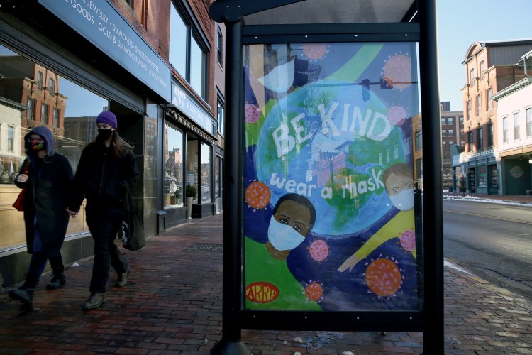 A poster on a bus stop on Congress Street advises the use of face coverings on Dec. 10.