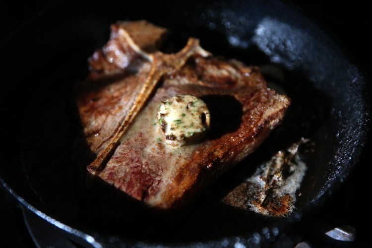 BRUNSWICK, ME - DECEMBER 3: A butter pat melts on a porterhouse steak. (Staff photo by Ben McCanna/Staff Photographer)