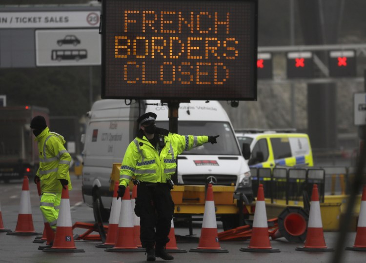 A police officer directs traffic at the entrance to the closed ferry terminal in Dover on Monday, after the Port of Dover was closed and access to the Eurotunnel terminal suspended. France banned all travel from the U.K. for 48 hours from midnight Sunday, including trucks carrying freight through the tunnel under the English Channel or from the port of Dover on England's south coast. 